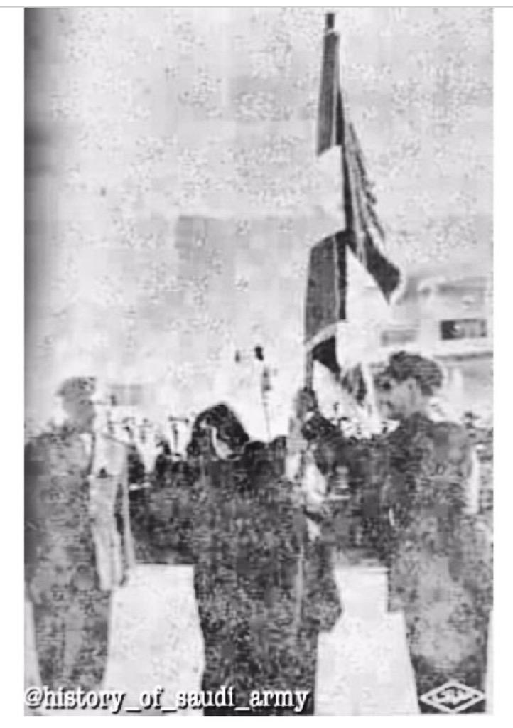 King Saud Hoisting the Saudi flag during the opening of the Military College
