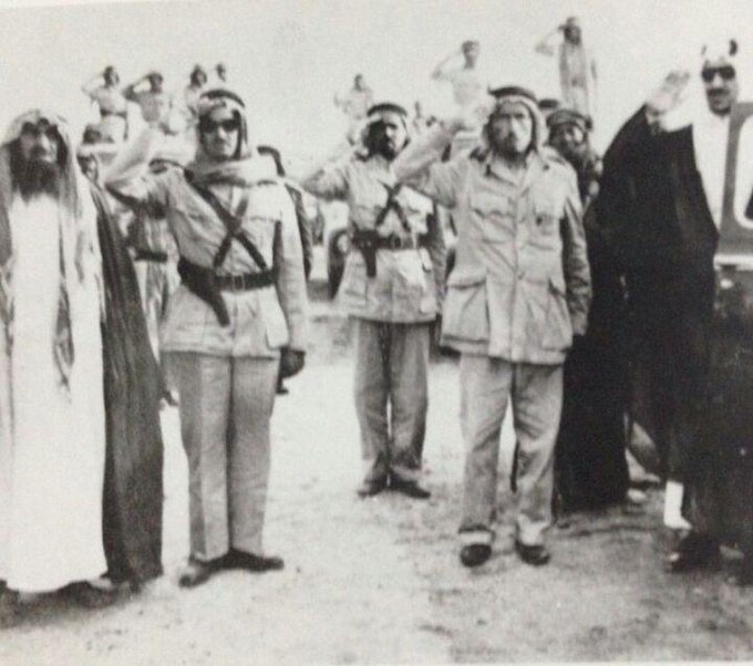 King Saud giving a military salute and next  Majid Al-Khatheelah appears on the photo