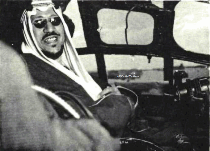 الملك سعود رحمه الله يبتسم وهو داخل مقصورة إحدى الطائرات الحربية خلال استعراض الطيران في مطار الظهران ١٩٥٥م.