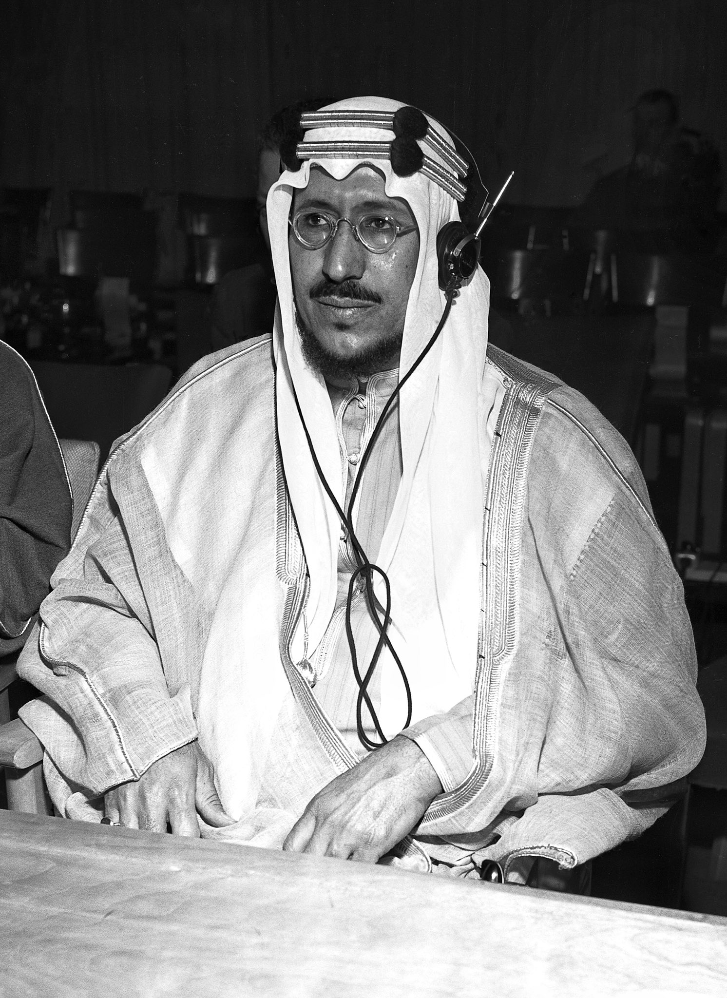 Crown Prince Saud of Saudi Arabia listening with the aid of a simultaneous interpretation set to the proceedings in the Security Council chamber, during his visit to the United Nations headquarters at Lake Success. [Exact date unknown] 01 January 1946 United Nations (Lake Success), New York