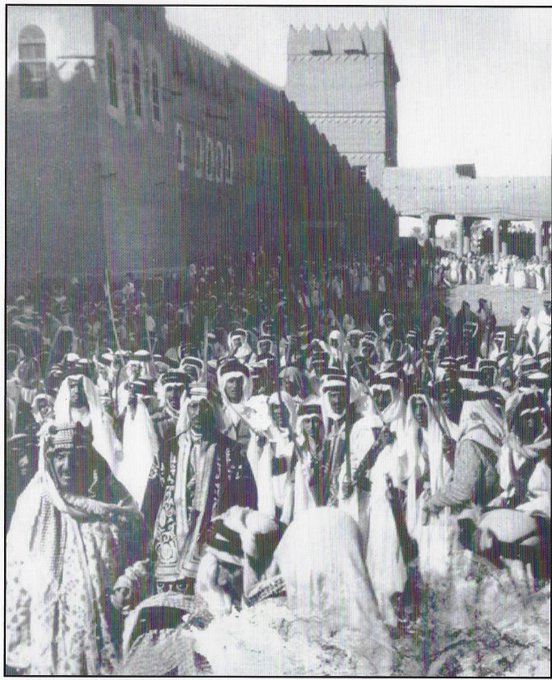Prince Saud, behind his father king Adbulaziz, in the middel of a great crowd