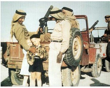 جنود من الحرس الملكي السعودي يداعبون اثنين من أطفال أرامكو الأجانب خلال زيارة الملك سعود لمرافق النفط بالظهران في 1954