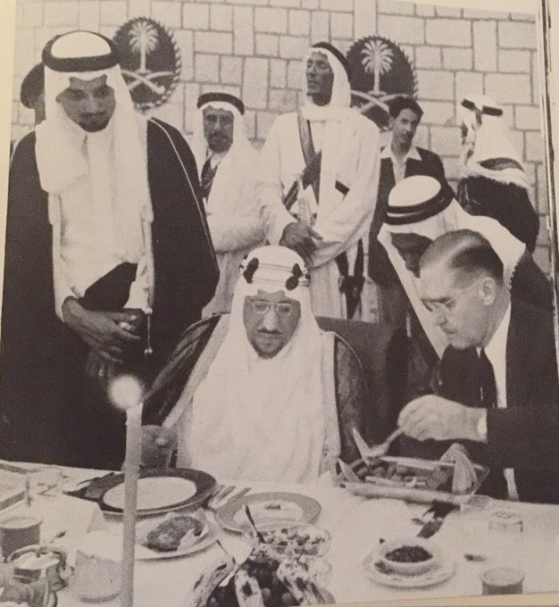 الملك سعود، مع رئيس أرامكو ف.أ.دافز  يقدم له الطعام في حفل على شرفه ١٩٥٧