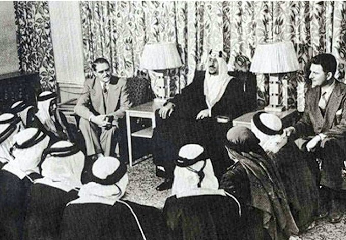 King Saud, may God have mercy on him during a meeting with a number of Saudi teachers before leaving to America to teach Aramcos new staff Arabic language.