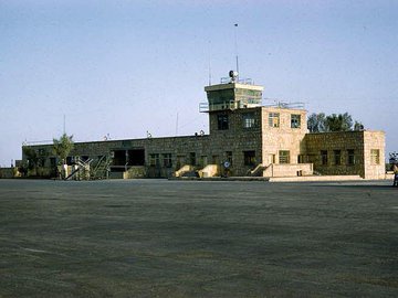 مطارالرياض القديم ويظهرالدوار الشهير الذي يضم مجسماً للدلال.. وكذلك مدخل المطار الذي أصبح الآن قاعدة الرياض الجوية