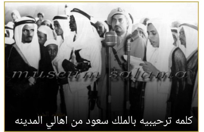 Ibrahim, son of Sheikh Abdullah bin Bazzāḥ, delivering an address before His Majesty King Saud — may God have mercy on them — at his father’s residence in Al‑Madinah Al‑Munawwarah in 1954.
