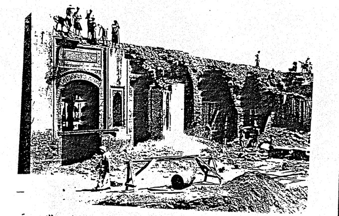 A documented moment from the first Saudi expansion of the Holy Mosque, depicting the demolition of the southern boundary and the presence of Bāb al‑Sharīf ‘Ajlān prior to its later redesign.