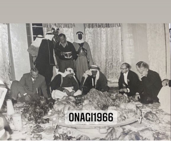 King Saud hosted by Sheikh Khalifa bin Hamad Al Thani during his visit to Qatar, with Sheikh Ali bin Abdullah Al Thani to his left, alongside British advisers, Emile Bustani, Abdulrahman bin Duraish Fakhro, and Mohammed Al‑Attiyah — 1955.