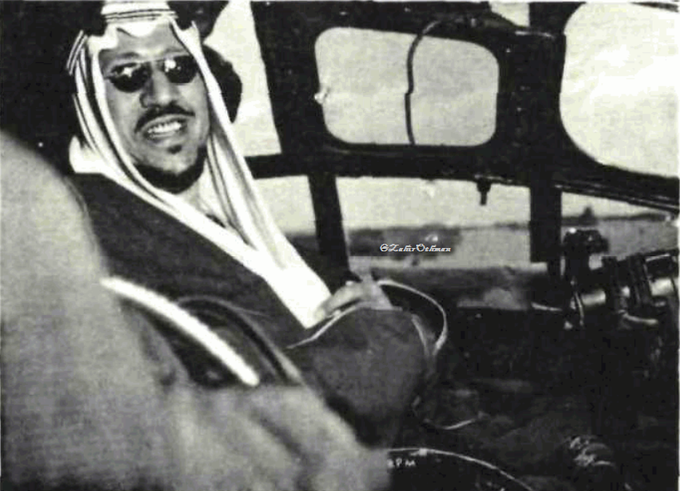 King Saud—may God have mercy on him—smiling inside the cockpit of a military aircraft during the air show held at Dhahran Airport in 1955.
