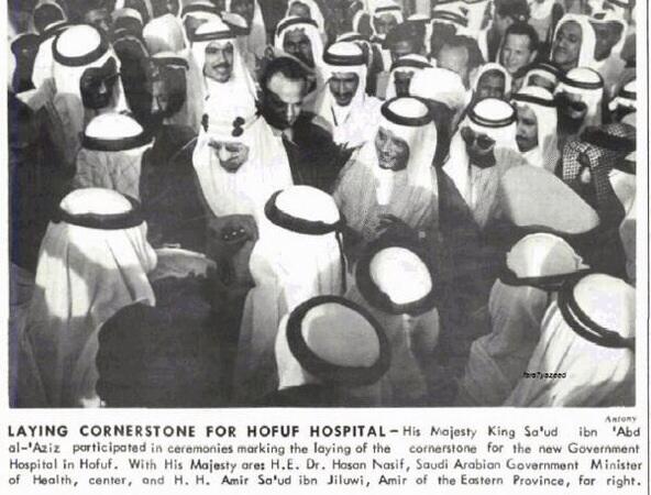 King Saud—may God have mercy on him—laying the foundation stone of al‑Hofuf Hospital in 1961, accompanied by Minister of Health Hassan Nassif and Prince Saud bin Jiluwi, Governor of the Eastern Province, as reported by the Arabian American Oil Company (ARAMCO) Bulletin.