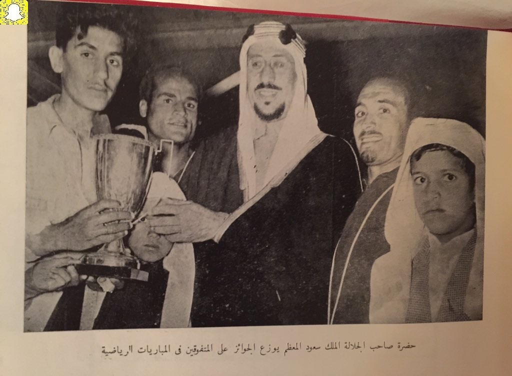 King Saud—may God have mercy on him—presenting the Anjal Institute Cup to his son Prince Khalid, with his son Prince Abdulmajeed—may God have mercy on him—standing beside them