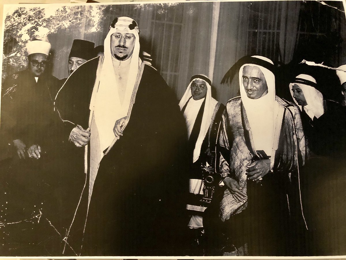 King Saud, with Sayyid Sadaqa Ka‘ki behind him on the left, and behind them Professor Fouad Shaker — may God have mercy on them — at one of the occasions.