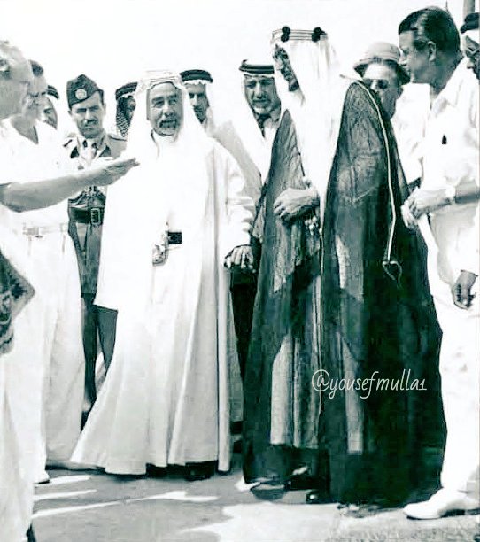 “King Saud (who was Crown Prince at the time) is seen holding the hand of King Abdullah bin Al‑Hussein of Jordan, with Sheikh Abdullah bin Adwan appearing behind them, in Dhahran in 1948