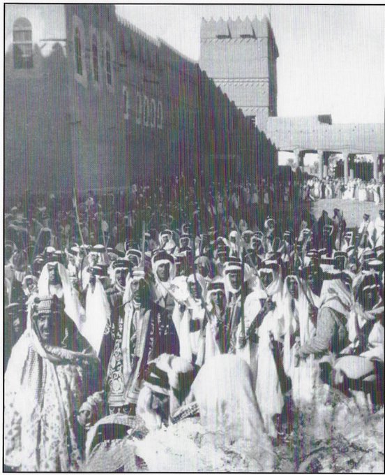 Prince Saud behind his father king Adbulaziz in the middel of a great crowd