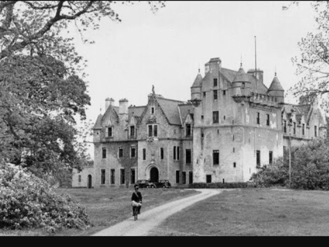 Photographed on 8 July 1937 at Udny Castle in Scotland, accompanied by Sheikh Yusuf Yassin, Dr. Medhat Sheikh Al‑Ard, and his aides Abdulaziz Al‑Rifai and Saleh Al‑Ali Al‑Salem.